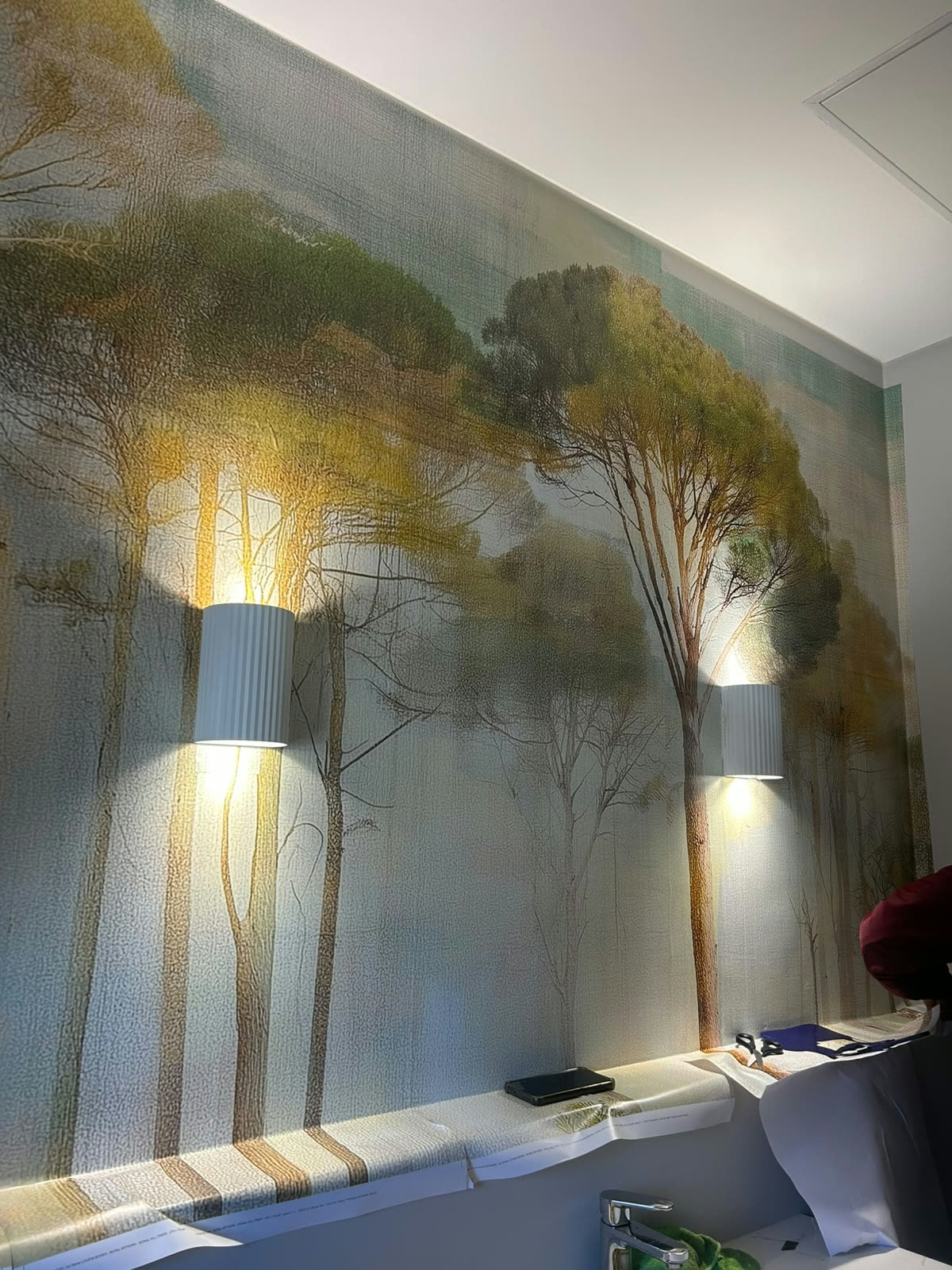 Completed tree mural with wall sconce lighting