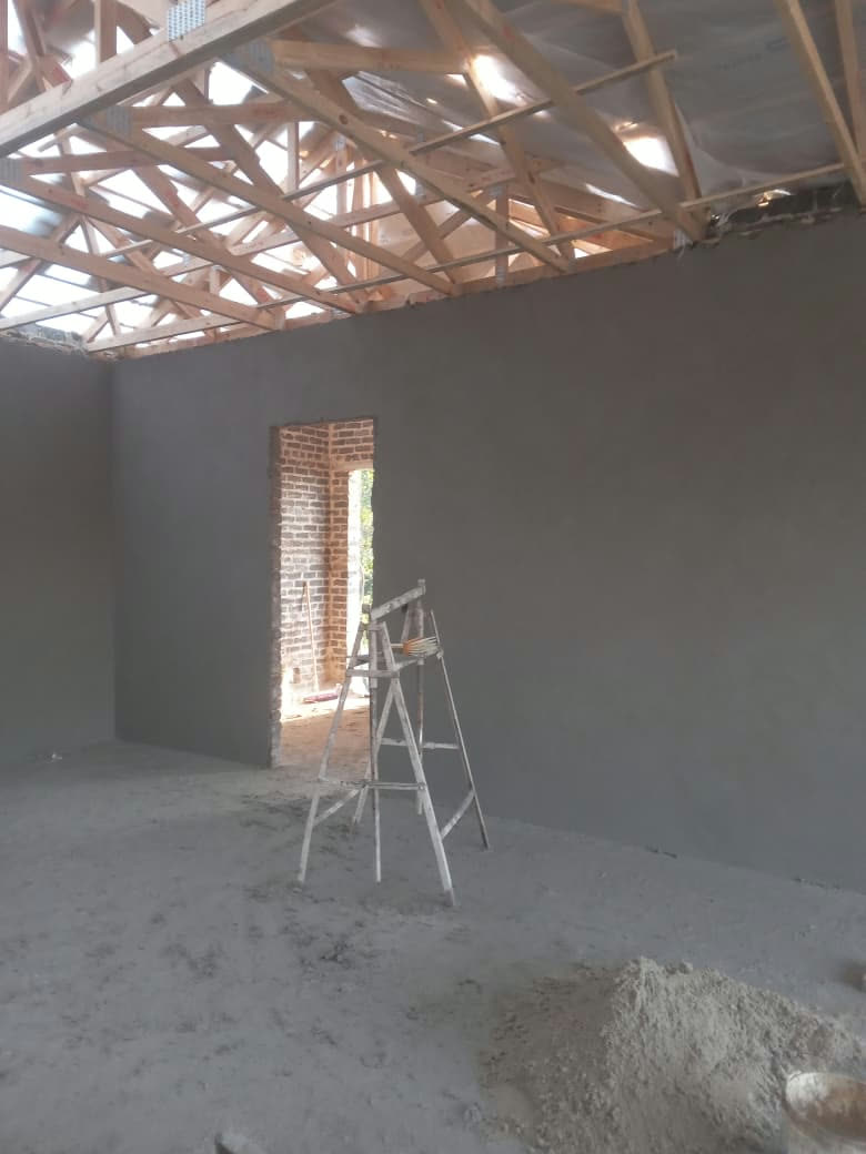 Freshly plastered walls under new roof trusses